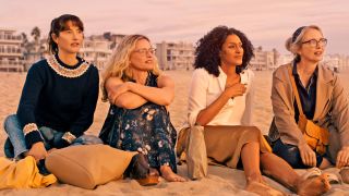 The cast of On the Verge sitting on the beach