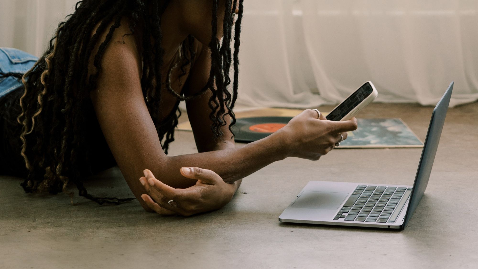 A woman lying on the floor scrolling on her phone