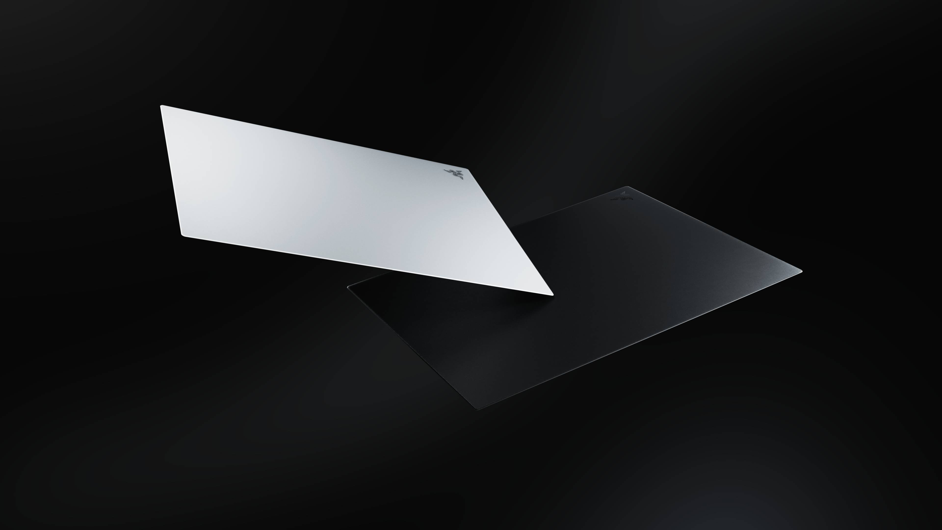 Two Razer Atlas Pro glass mouse pads floating in the void.