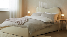 oatmeal colored bed from habitat in a neutral room with a wave shaped headboard 