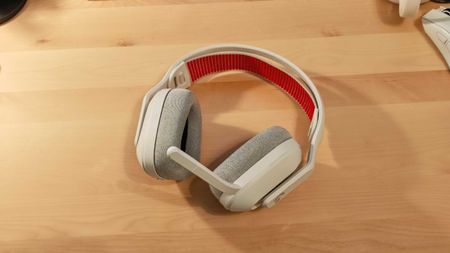 The Astro A20 X gaming headset on a wooden desktop surface.