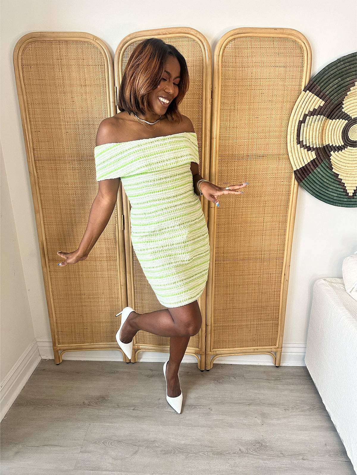 Tiffany Reid wearing a tweed minidress and white heels for a TV segment.