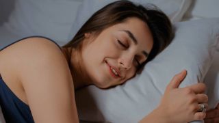 Smiling woman lying on a pillow with her eyes closed