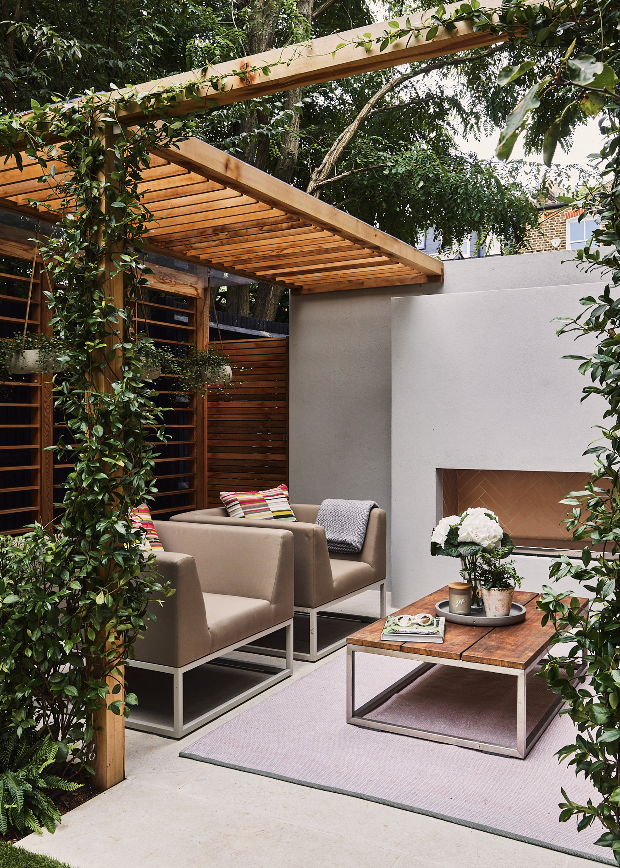 patio with timber pergola, pale grey slabs and modern furniture