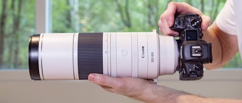 Canon RF 200-800mm F6.3-9 lens in the hand, attached to Canon EOS R5
