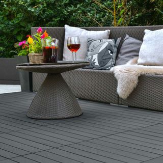 outdoor space with pillows on grey sitting arrangement and wine glass on table