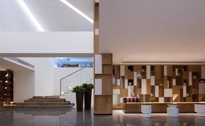 The lobby is a grand triple-volumed stage set crowned by a peaked dome with striated light panels