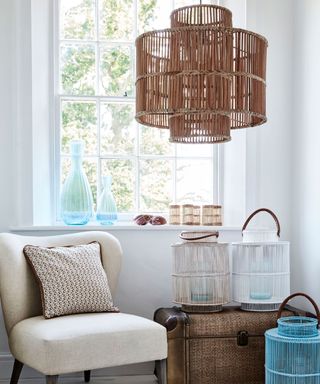 Statement rattan pendant light above occasional chair and bamboo lanterns.