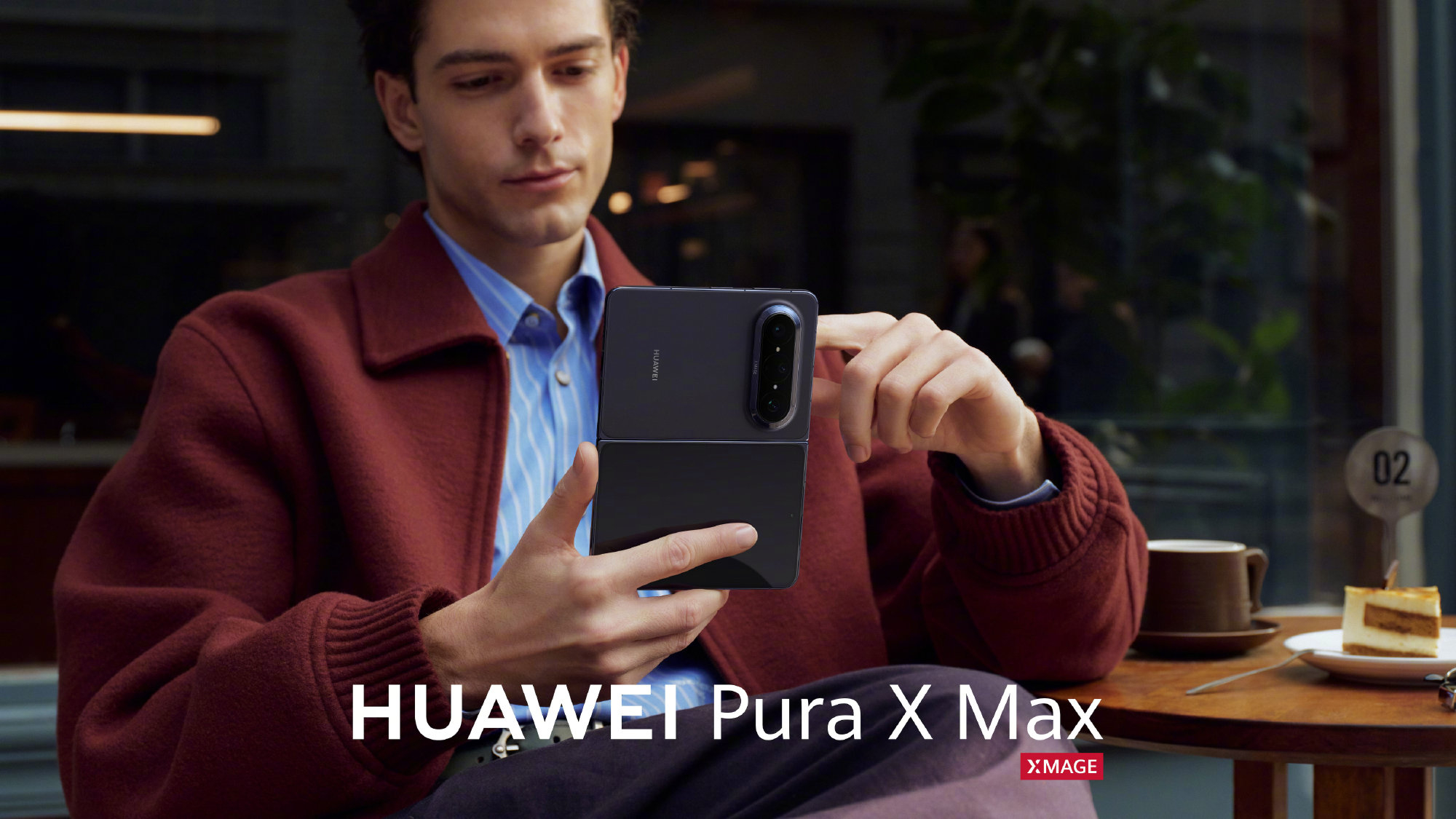 A man looking at a black Huawei Pura X Max in hand