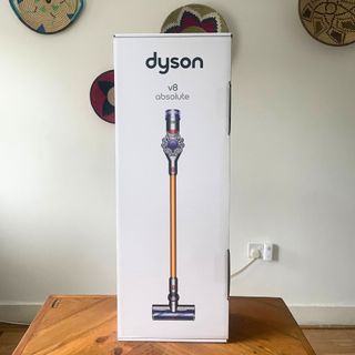 Dyson V8 Absolute in box sitting on a dining room table