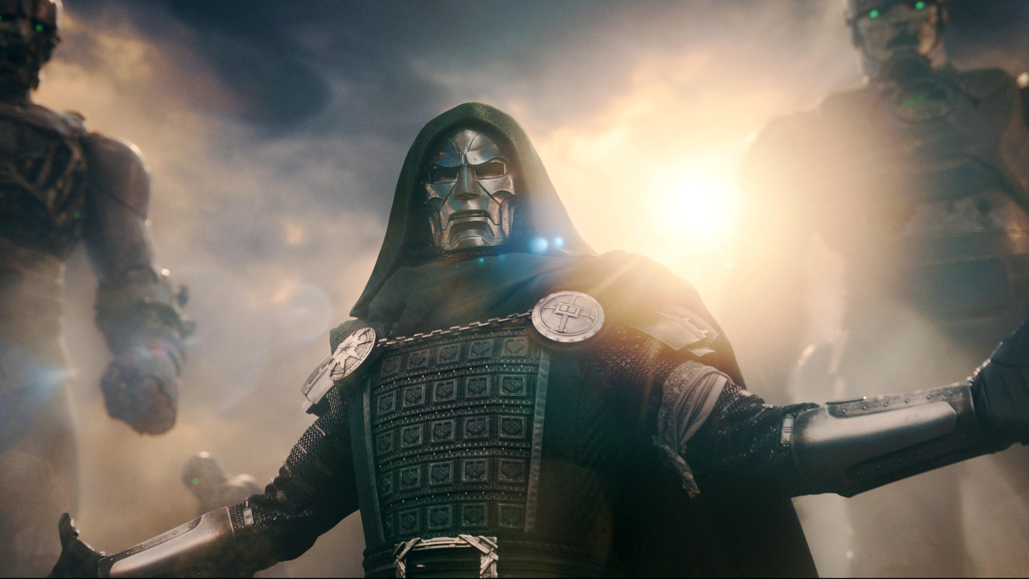 Doctor Doom (Downey jr) stands in his iconic green robe and armor, arms stretched out, sentinels looming over his shoulder in Avengers: Doomsday (2026).