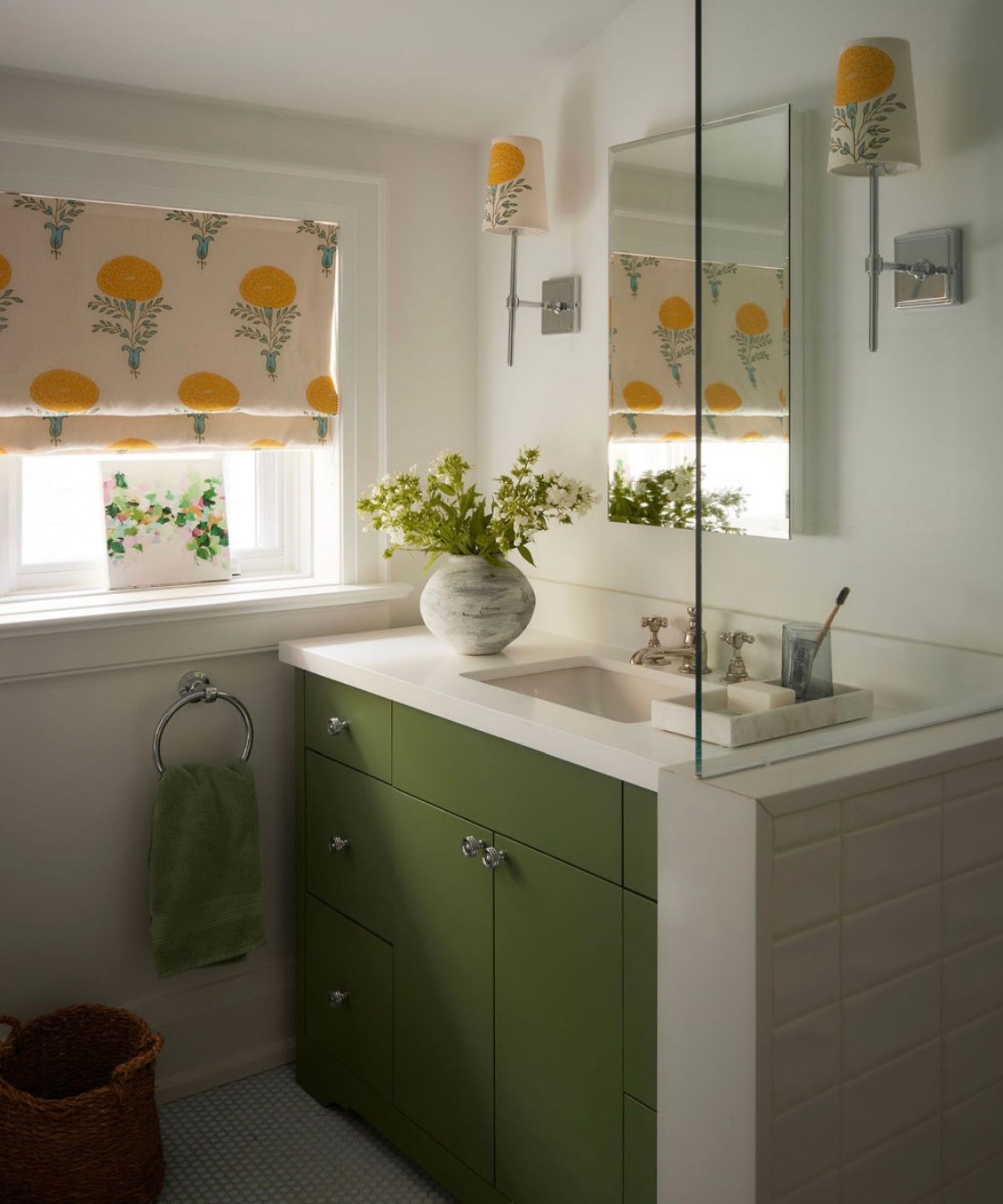 A bathroom painted in White Dove by Benjamin Moore with a green vanity painted Cushing Green by Benjamin Moore, and patterned window treatments