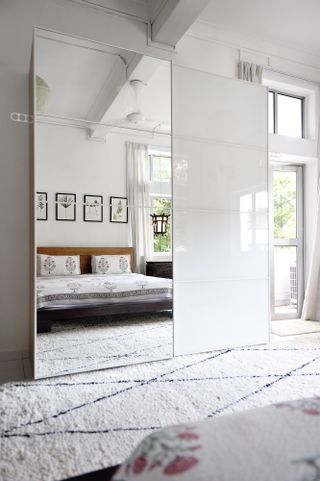 A bed facing the mirrored closet