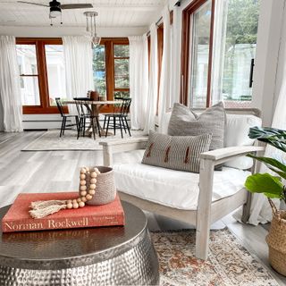 Sunroom with white flush armchair, coffee table, grey vinyl floors