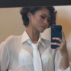 Zendaya posed in all bridal white, beginning with a sheer button-down, a peekaboo bra, and the neck tie trend