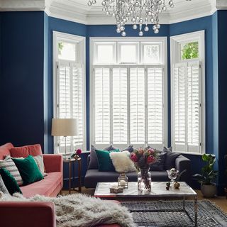 living room with blue wall and white windows