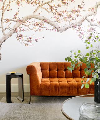 living room with ombre drapery, rust sofa and tree mural