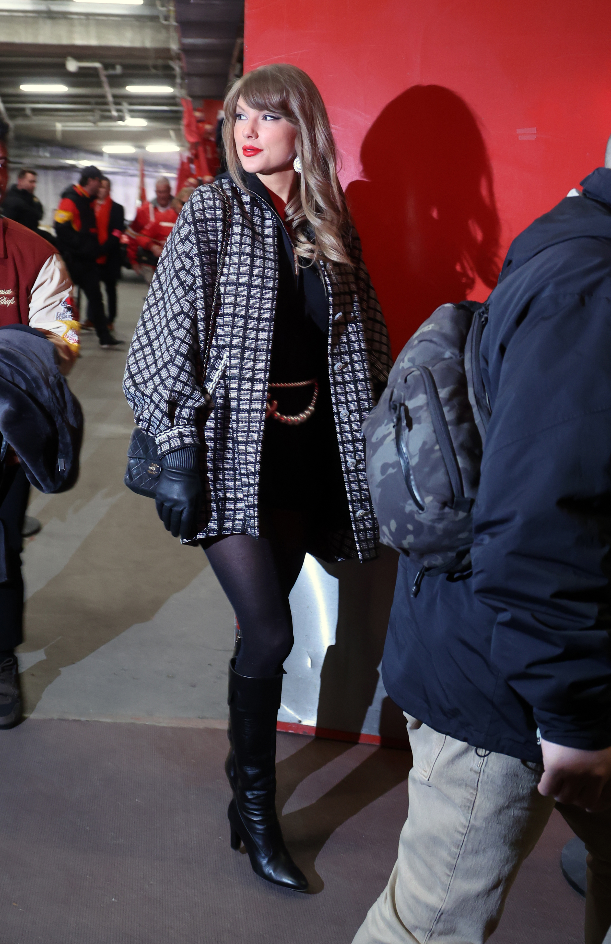 Taylor Swift wearing a Chanel plaid jacket and knee-high boots on her way to a Chiefs game