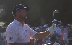 Bryson DeChambeau pulls an iron out of his bag