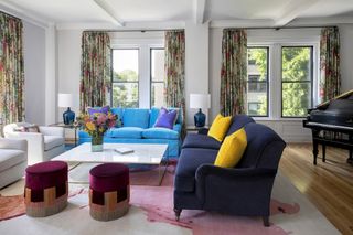 A living room with different colored sofas