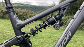 Close up of suspension on Merida One-Sixty FR with field and hills in background