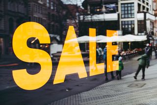 Large retail glass window shows the word SALE in capitals