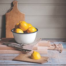 Wooden cutting boards with a bowl of lemons