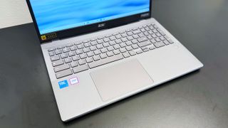 Angled shot of the Acer Chromebook Plus Enterprise 515's keyboard deck, on a black desk against a white background.