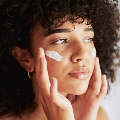 Woman applying moisturiser