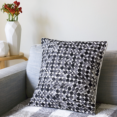 grey sofa with cushion on monochrome print and flower vase