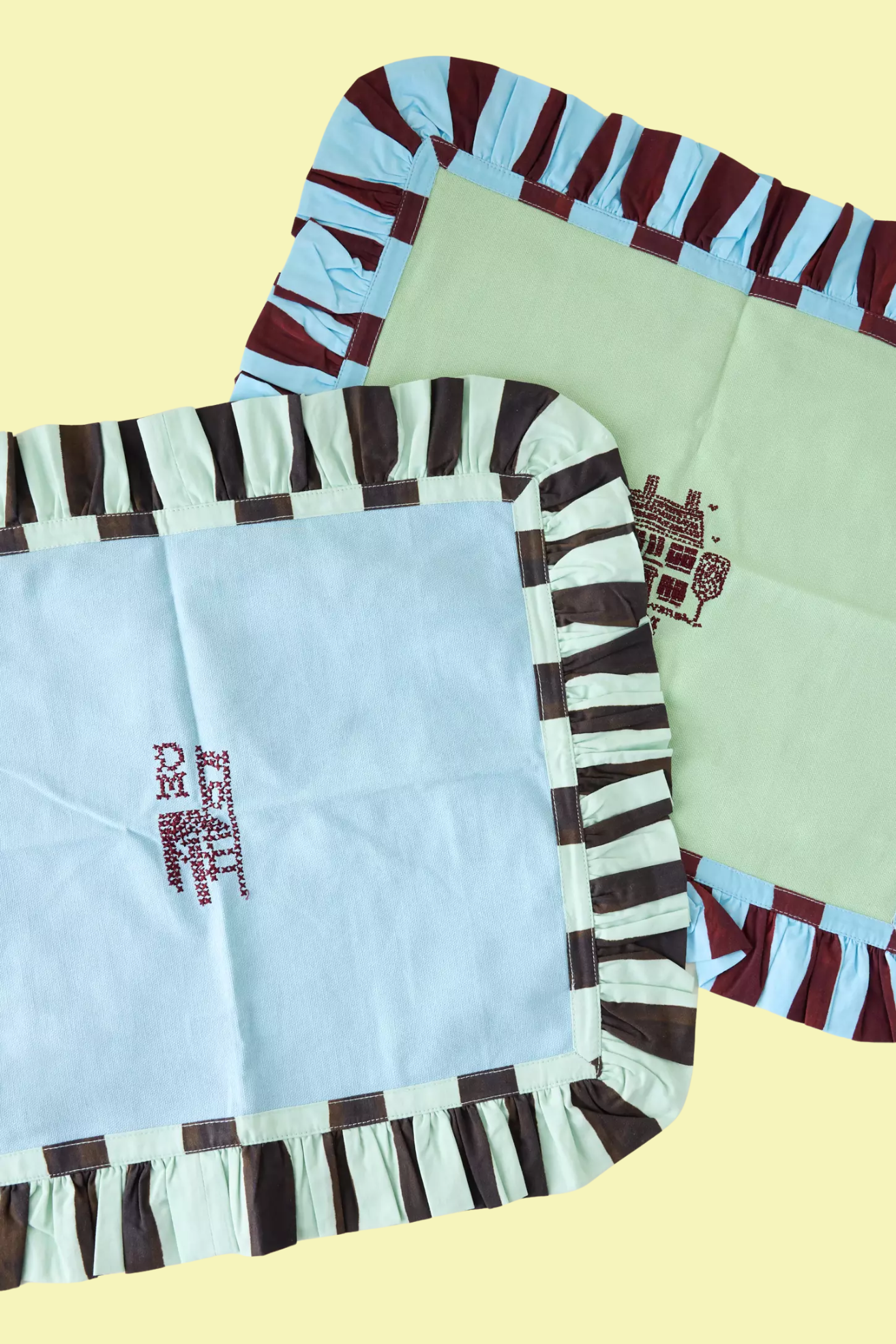 A pair of ruffled embroidered placemats