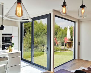 Modern sliding doors with contemporary pendant lights and a view of the garden outside