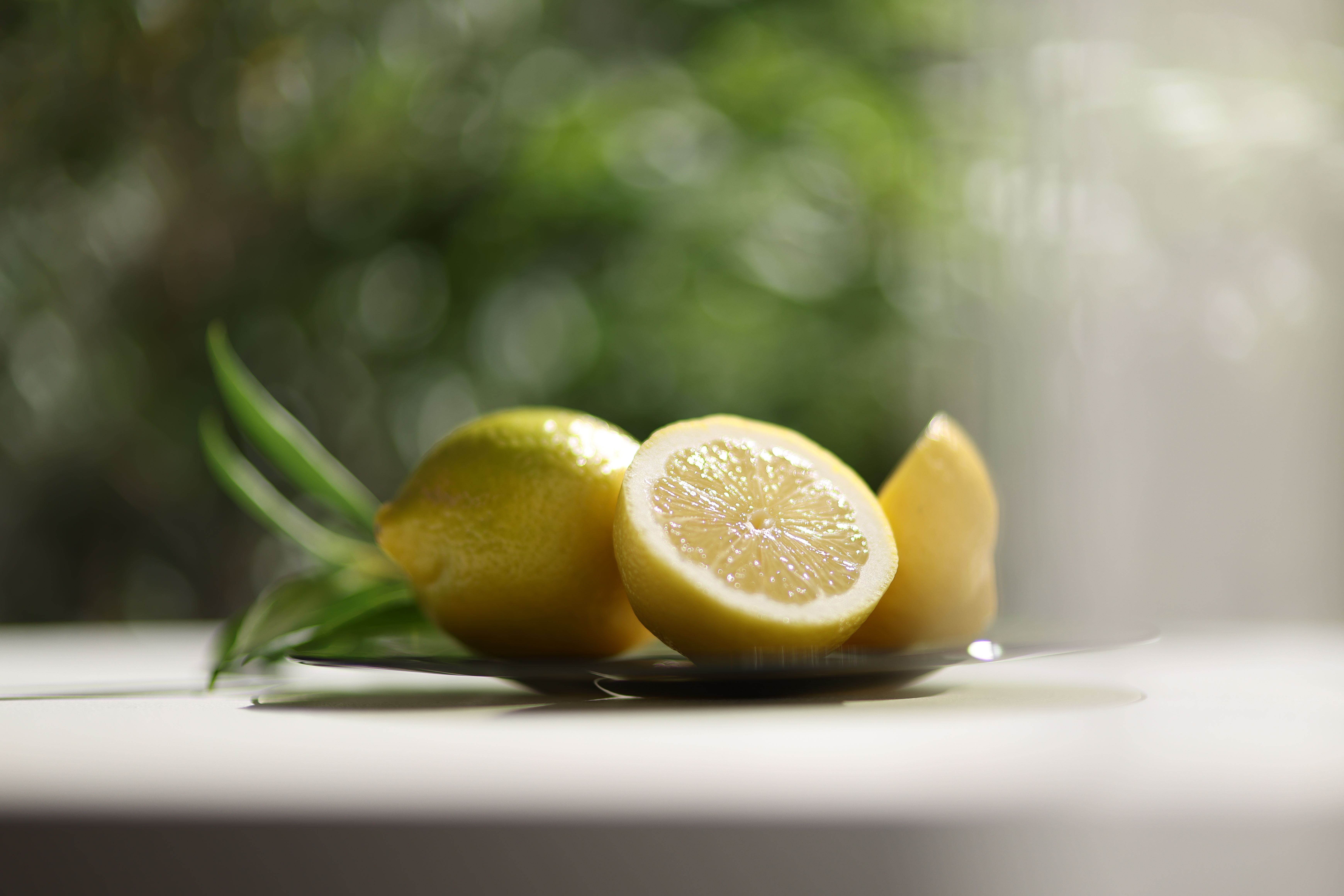Canon RF 45mm F1.2 STM sample images: a sliced lemon on a white surface with green foliage backdrop