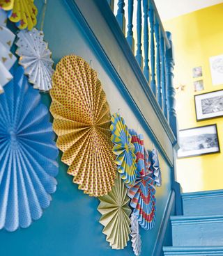 blue stair case with blue railing and paper decorations
