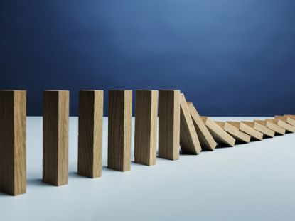 a line of dominoes that are falling over while others remain standing