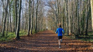 man running in woodland and wearing gilet