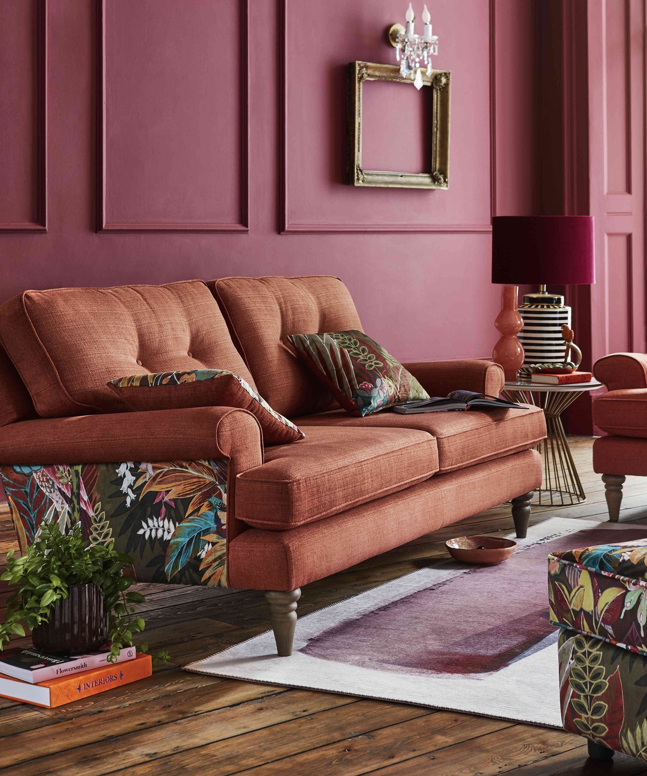 A warm red living room with board and batten wall paneling decor and brass wall sconce light fixture