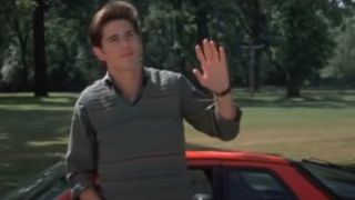 Jack Ryan waving in front of a car in Sixteen Candles