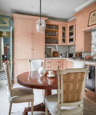 Cozy kitchen with pink cabinetry and antique furniture