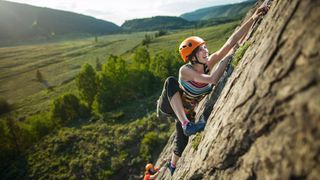 A guide to climbing ratings: climber smiling on a crag