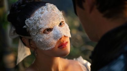 A masked Sophie looks up at Benedict