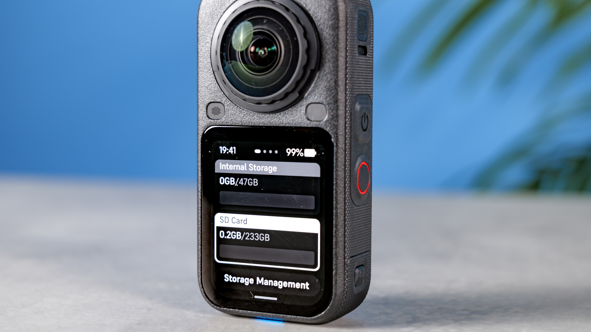 A photo of the Insta360 X6 on a stone surface, one the screen are the internal storage and SD card storage displays