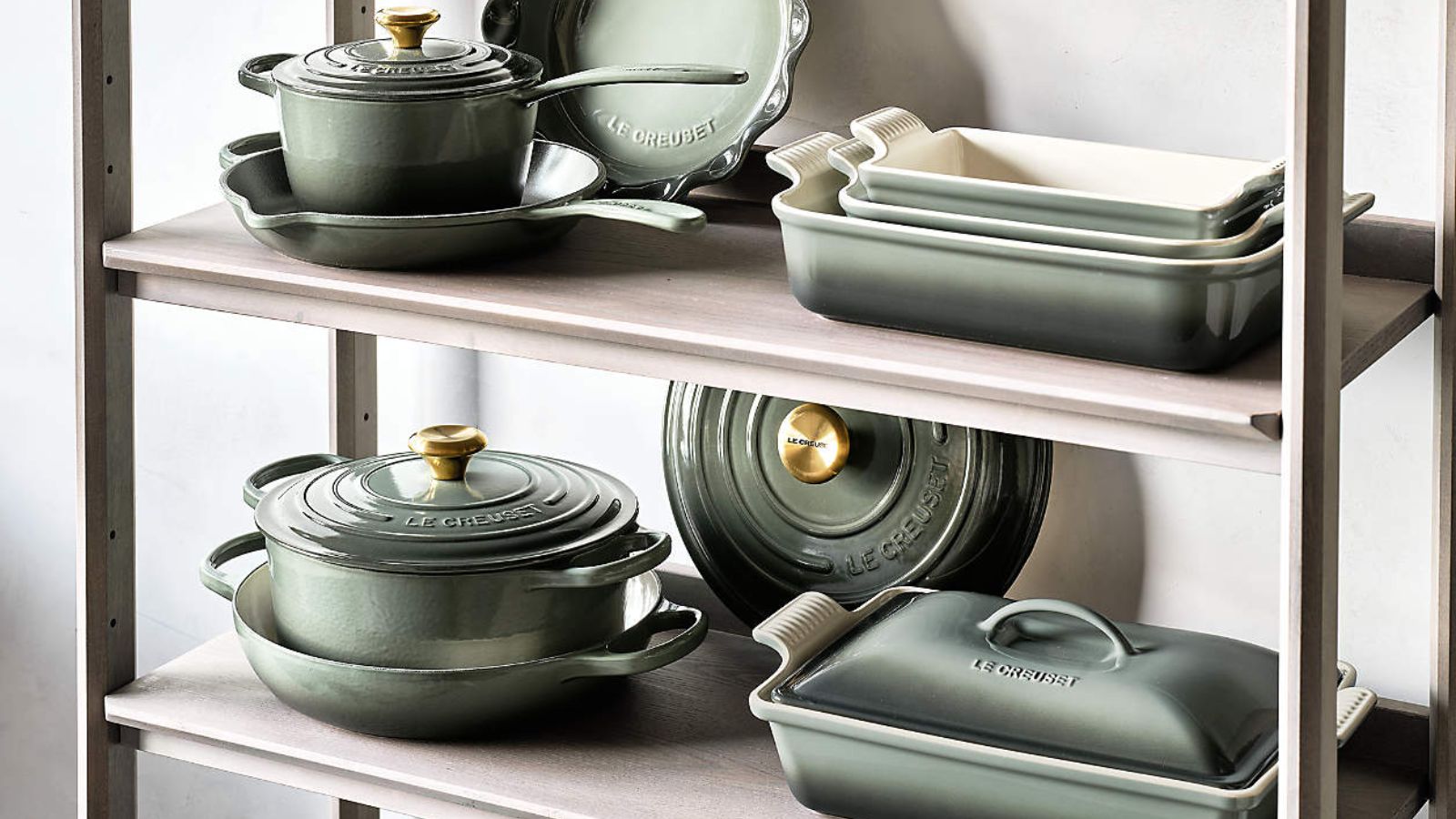 Sage green Le Creuset dishes including braisers, Dutch ovens, and baking dishes