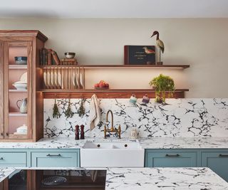 green kitchen with marble worktops and open kitchen shelving