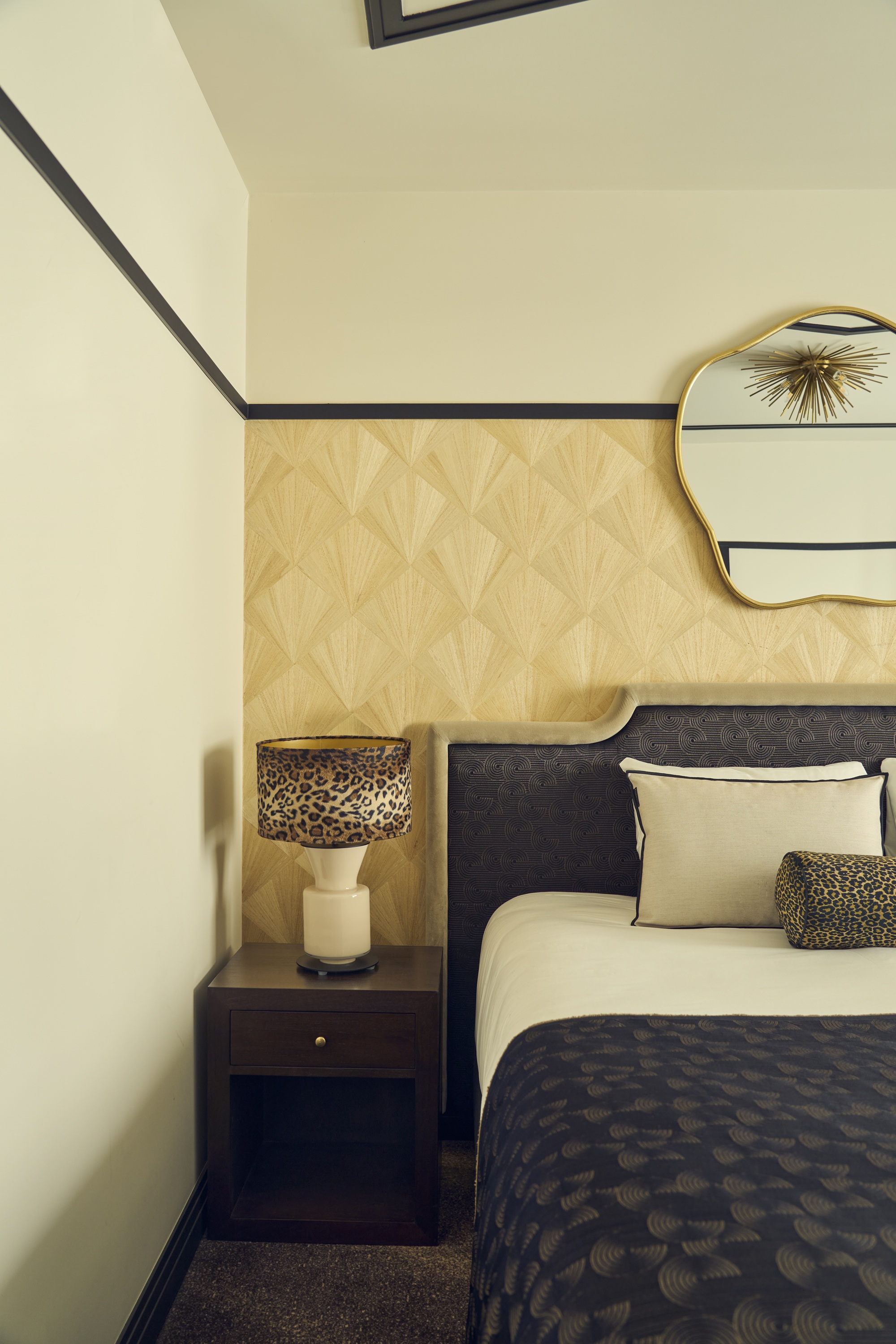 an art deco hotel bedroom with an art deco wallpaper and contrast black trim