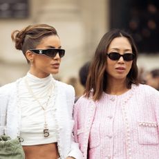 Camila Coelho wears mint green jeans, white turtleneck cropped top, white jacket, green bag and sunglasses and Aimee Song wears blue jeans, pink jacket and beige bag outside the Chanel fashion show during the Womenswear Fall/Winter 2025/2026 as part of Paris Fashion Week on March 11, 2025 in Paris, France