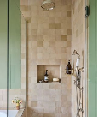 shower with zellige tiles chrome hardware and a shower niche with green paneled walls