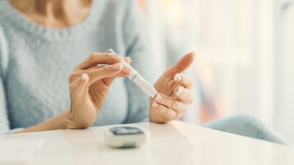 A woman tests her blood sugar.