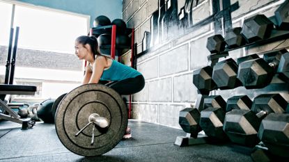 woman at bar dumbbells vs barbells