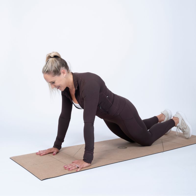 Sarah Campus demonstrating how to do a push up on yoga mat in the starting position
